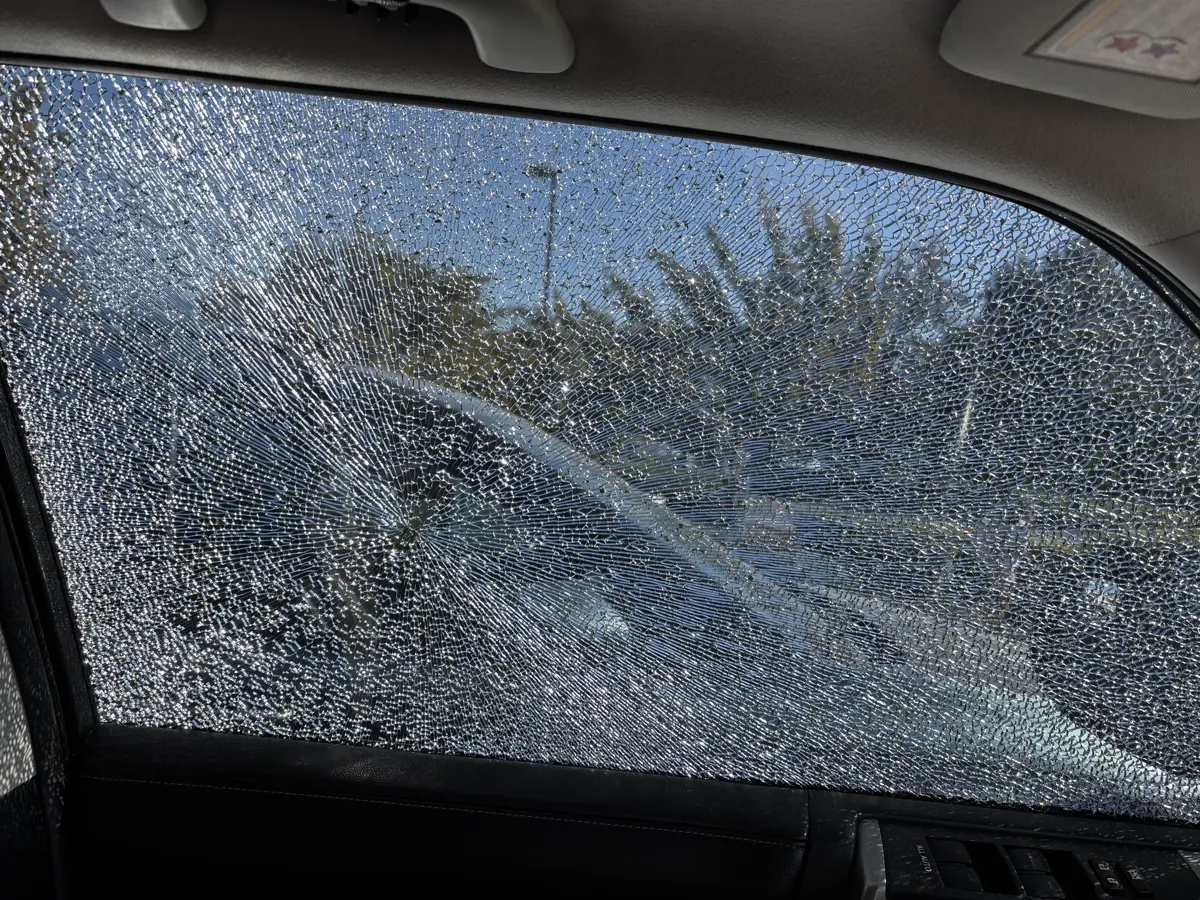 Shattered front door glass on an SUV before side window replacement